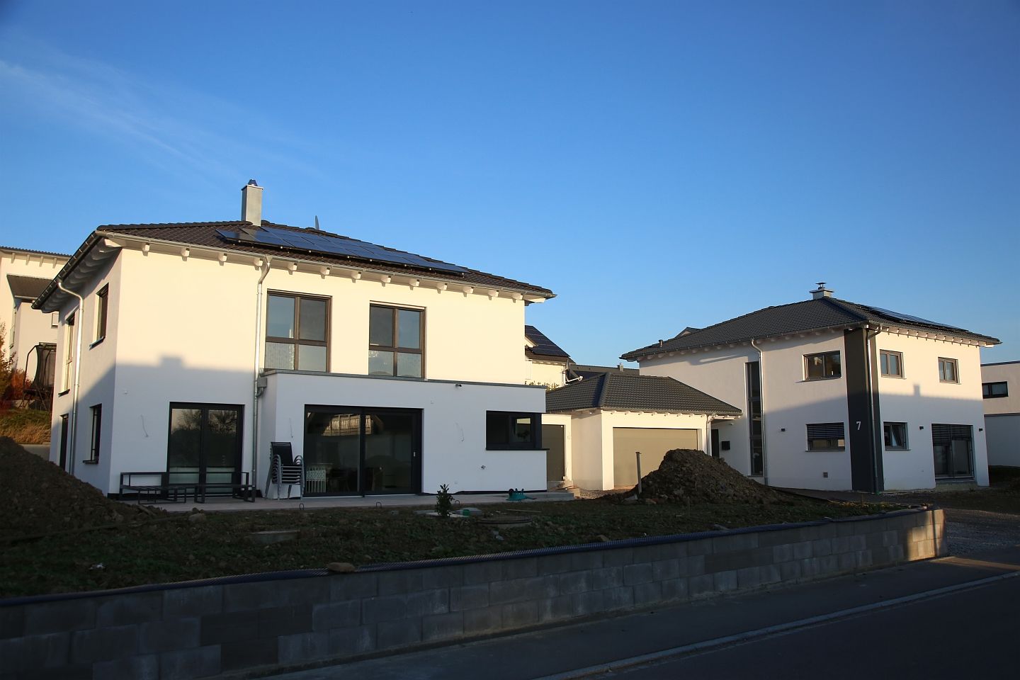 Stadtvilla weiß mit schwarzen Dachziegeln, Garten und Garage